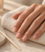 Natural manicure beside cuticle oil and a wooden manicure stick